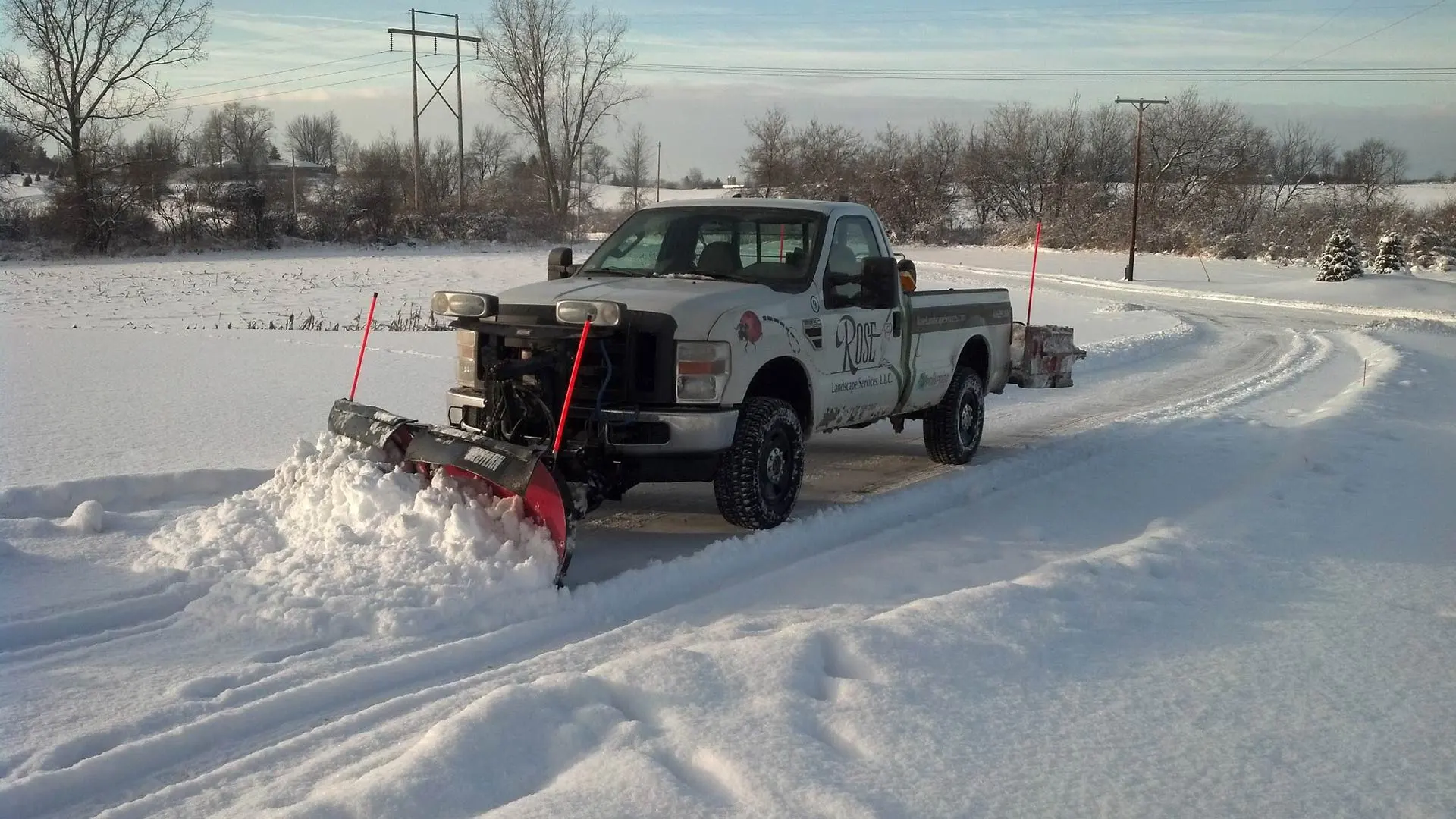 Rose Landscaping company truck plowing snow in Grand Rapids, MI.
