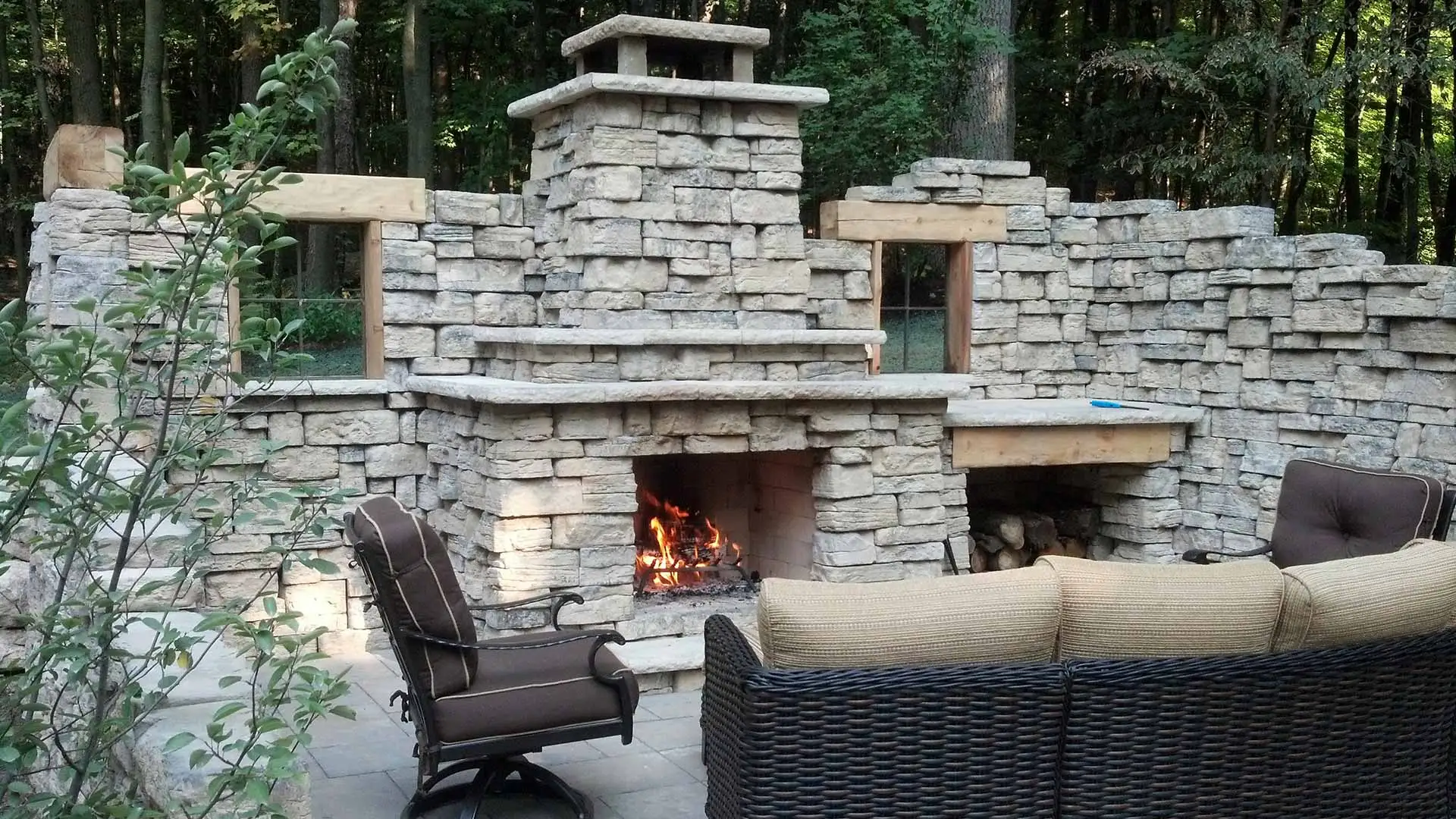 Custom stone outdoor fireplace and seating area in Grand Rapids, MI.