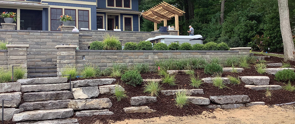 Our client's finished backyard complete with hot tub, retaining walls, pergola, and more in Ada, MI. 