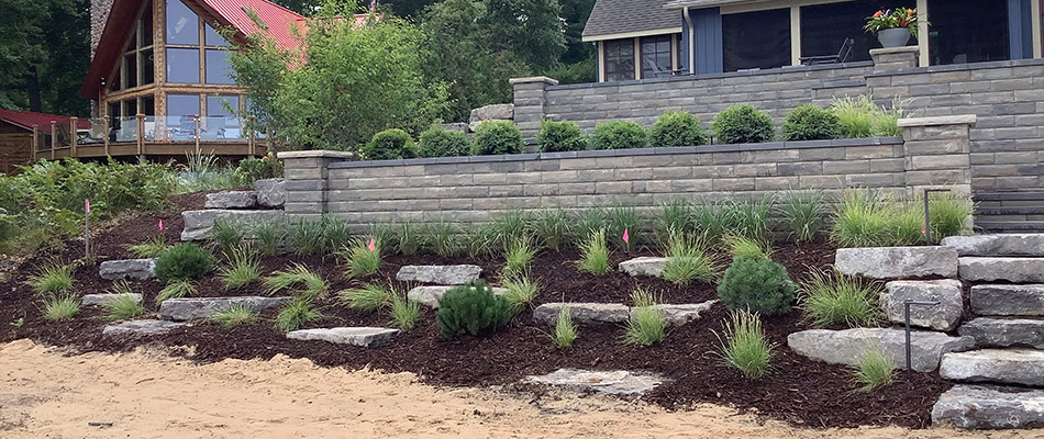 Newly built retaining walls, steps, and landscape beds behind our client's home in Ada, MI. 