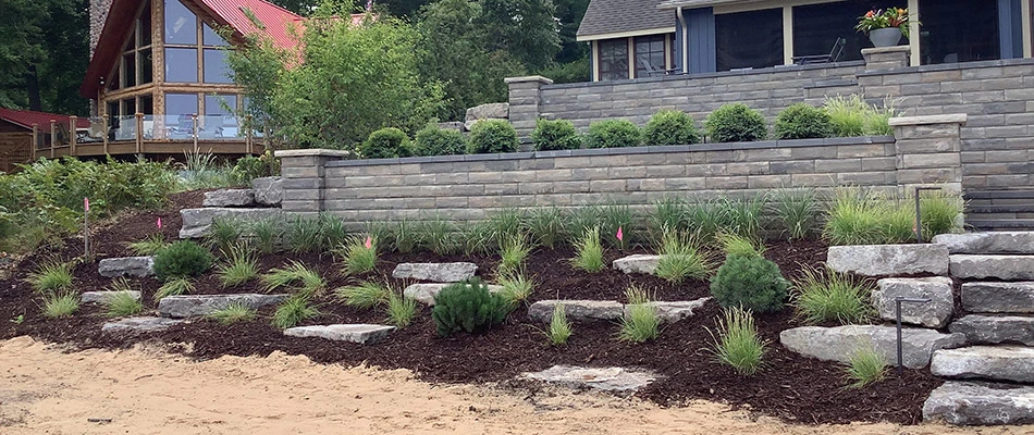 Newly built retaining walls, steps, and landscape beds behind our client's home in Ada, MI. 