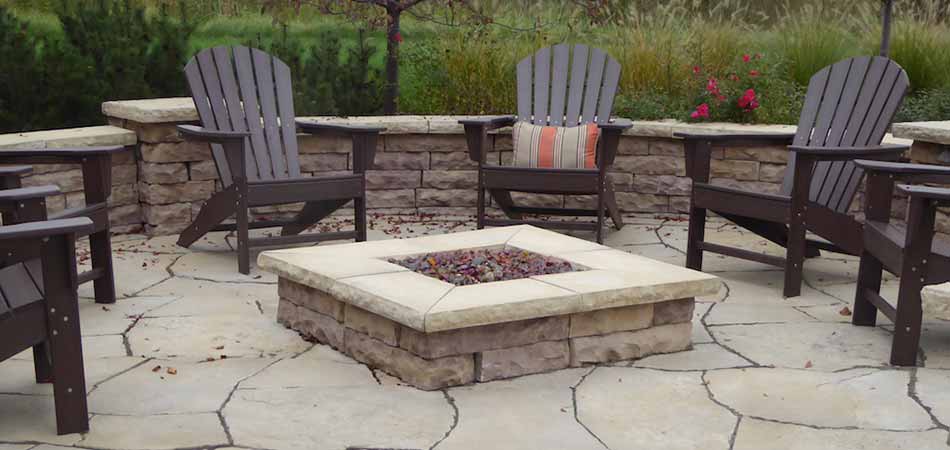 Custom outdoor seating area with stone fire pit in Cascade, MI.