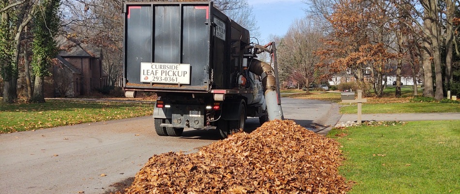 Curbside leaf removal truck picking up piles of leaves in Kentwood, MI.