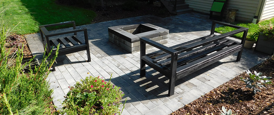 Fire pit built out of smooth black pavers in Holland, MI.