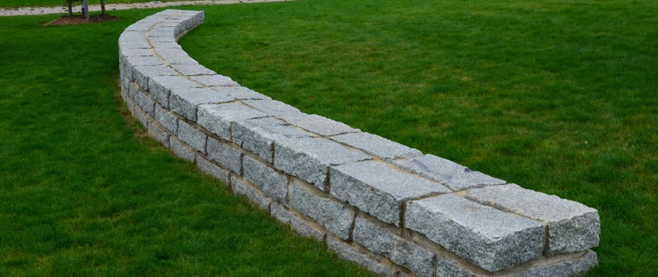 Seating wall installed in green lawn in West Olive, MI.