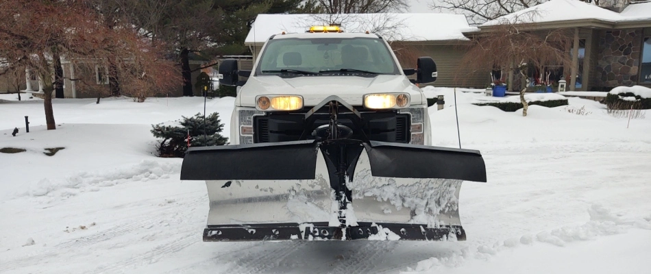 Truck with snow plow to clear driveway in Ada, MI.